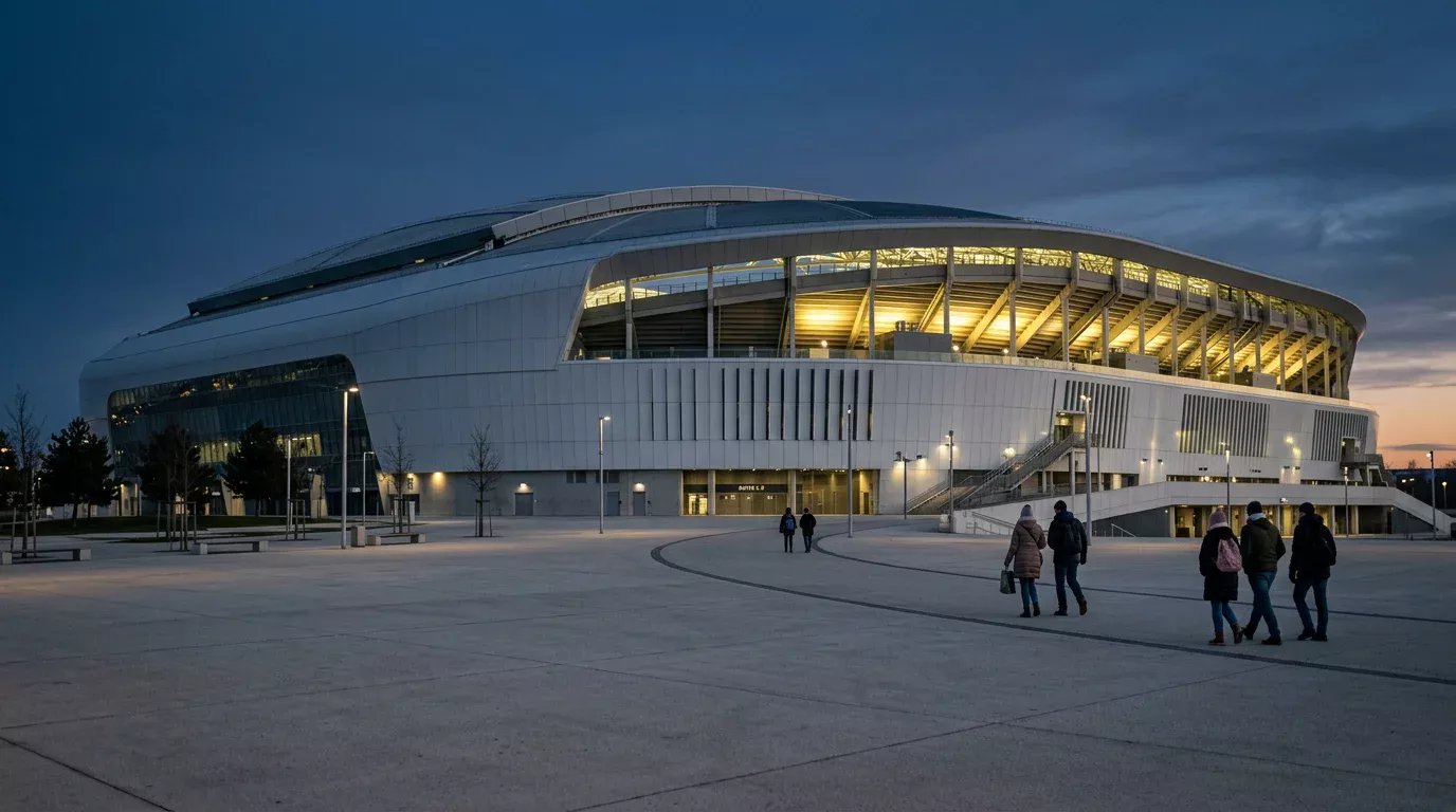 Modern voetbalstadion met gesloten dak in de avond, exterieur verlicht