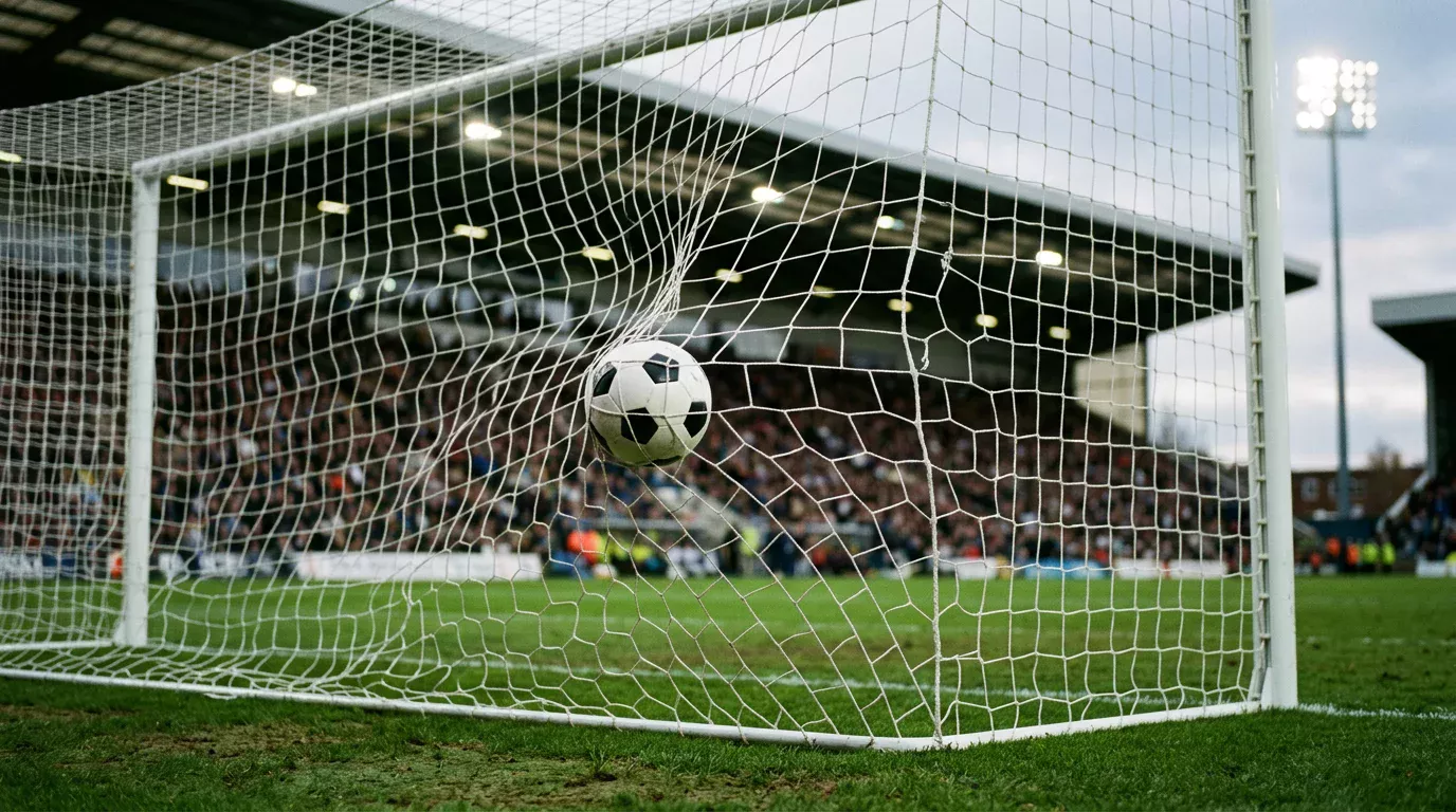 Voetbal in het net van een doel met witte palen tijdens een wedstrijd